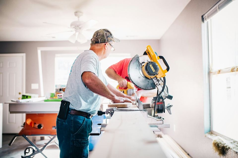 Two local home repair pros working together inside a bright home